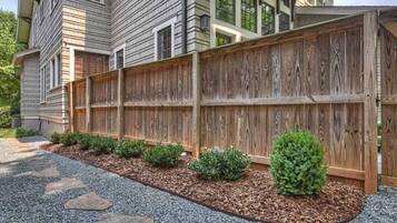 A wooden fence with a stone pathway leading to a house.