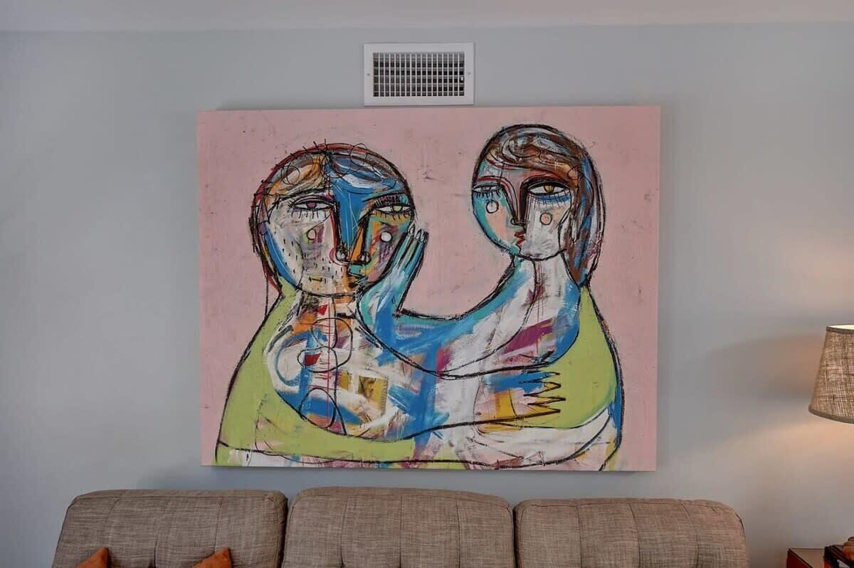 A painting on a wall above a sofa.