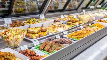 A buffet with various food items and a salad bowl.