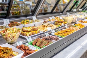 A buffet with various food items and a salad bowl.