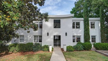 A white building with a central entrance, multiple windows, and a number '510' on the facade.