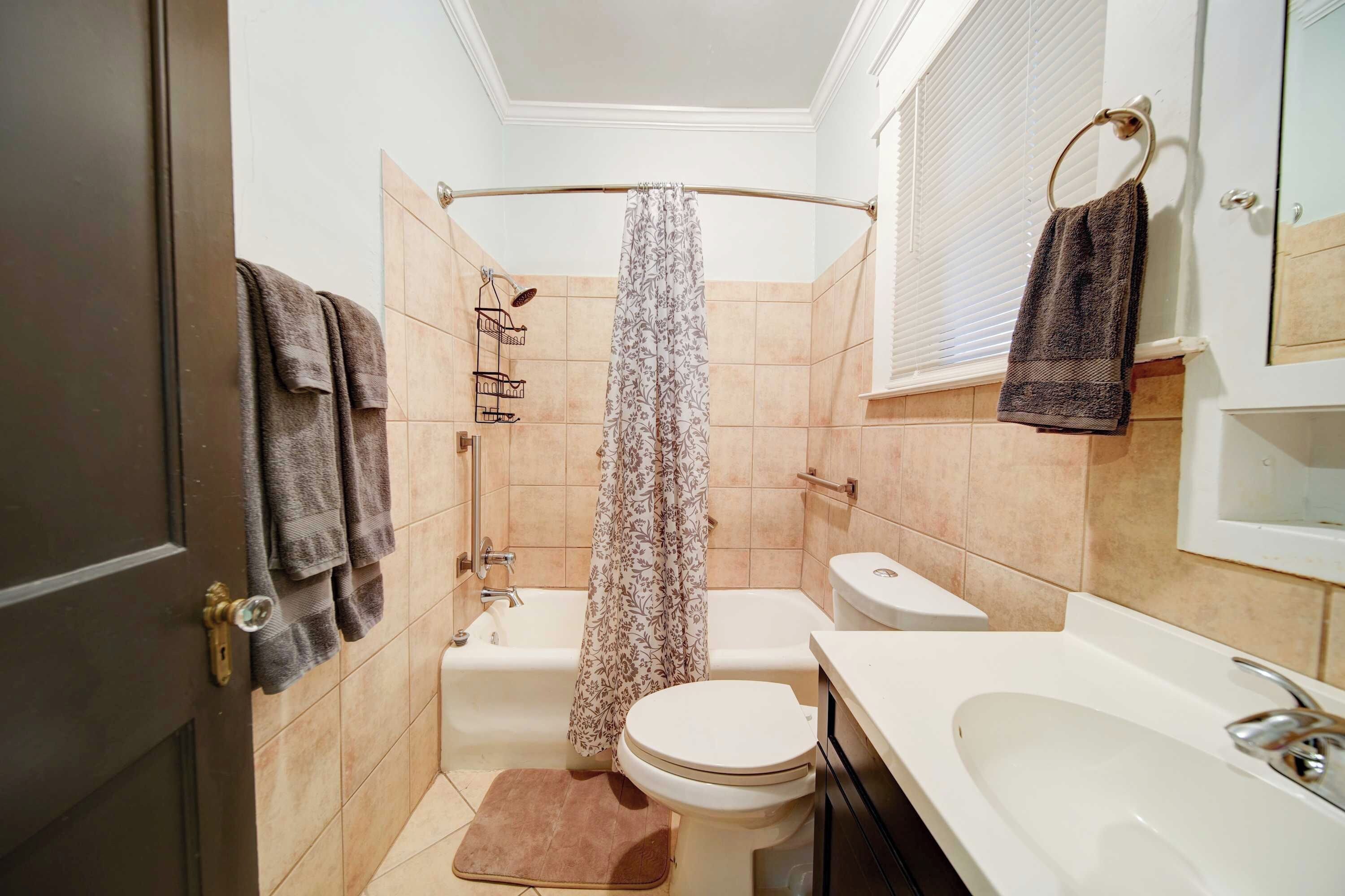 Un baño pequeño con ducha, inodoro y lavamanos.