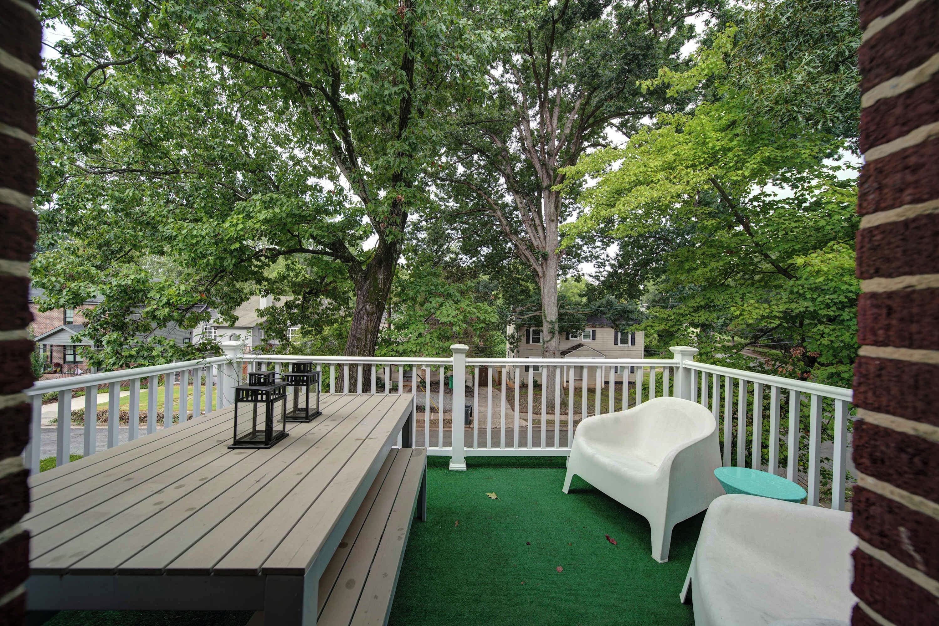 Enjoy peaceful, tree-lined Charlotte neighborhood views from the furnished outdoor balcony, a relaxing spot for morning coffee or evening downtime.