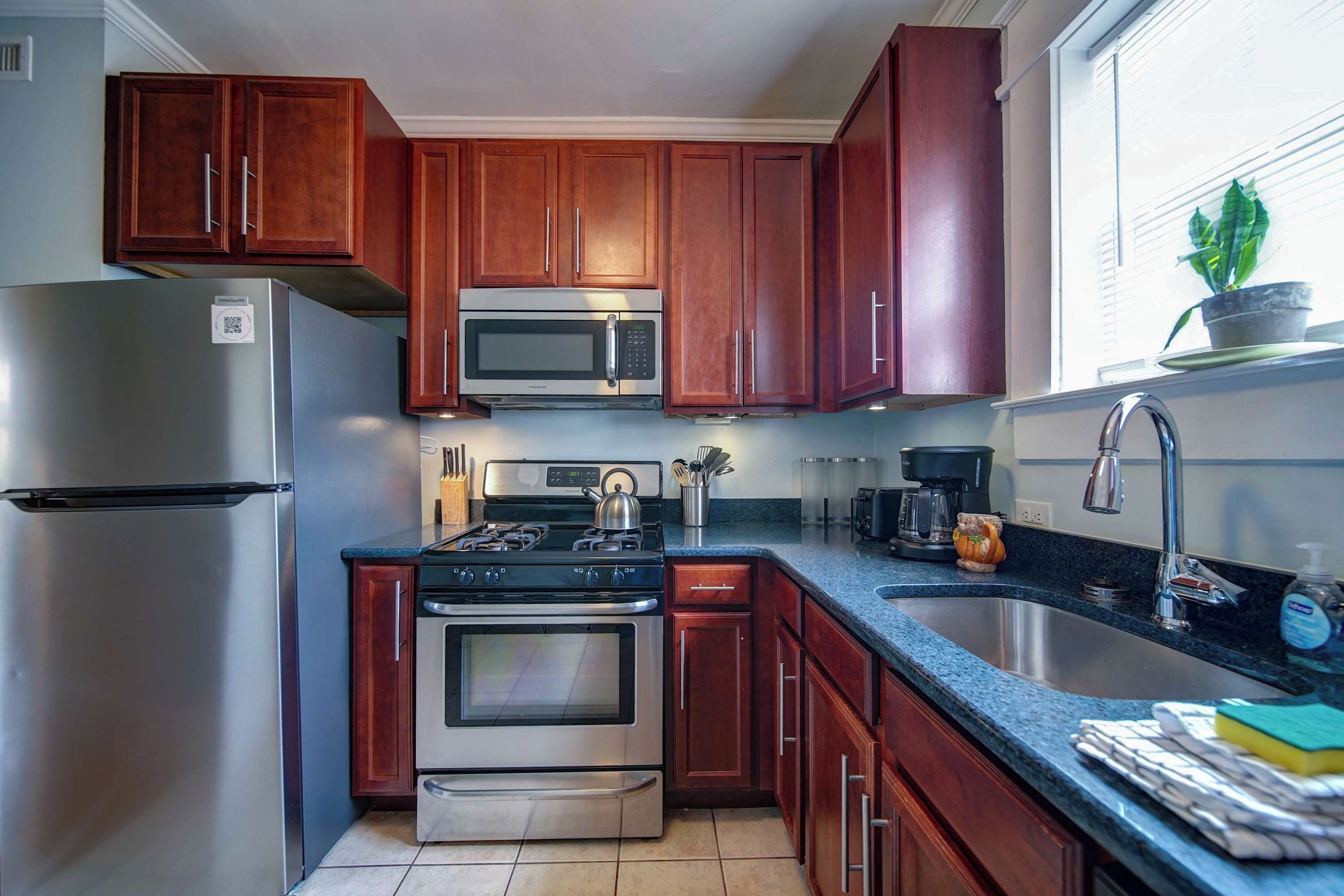 A kitchen with wooden cabinets, stainless steel appliances, a gas stove, and a sink.