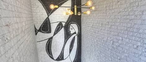 A staircase with a modern light fixture and a mural on the wall.