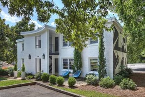 A modern two-story house with a curved facade, satellite dishes, and a well-maintained garden. - Boutique Myers Park King Suite Condo with Parking Near Atrium CMC & Uptown (Charlotte)