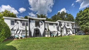 Une maison moderne dotée d’une façade géométrique originale et d’une pelouse bien entretenue.