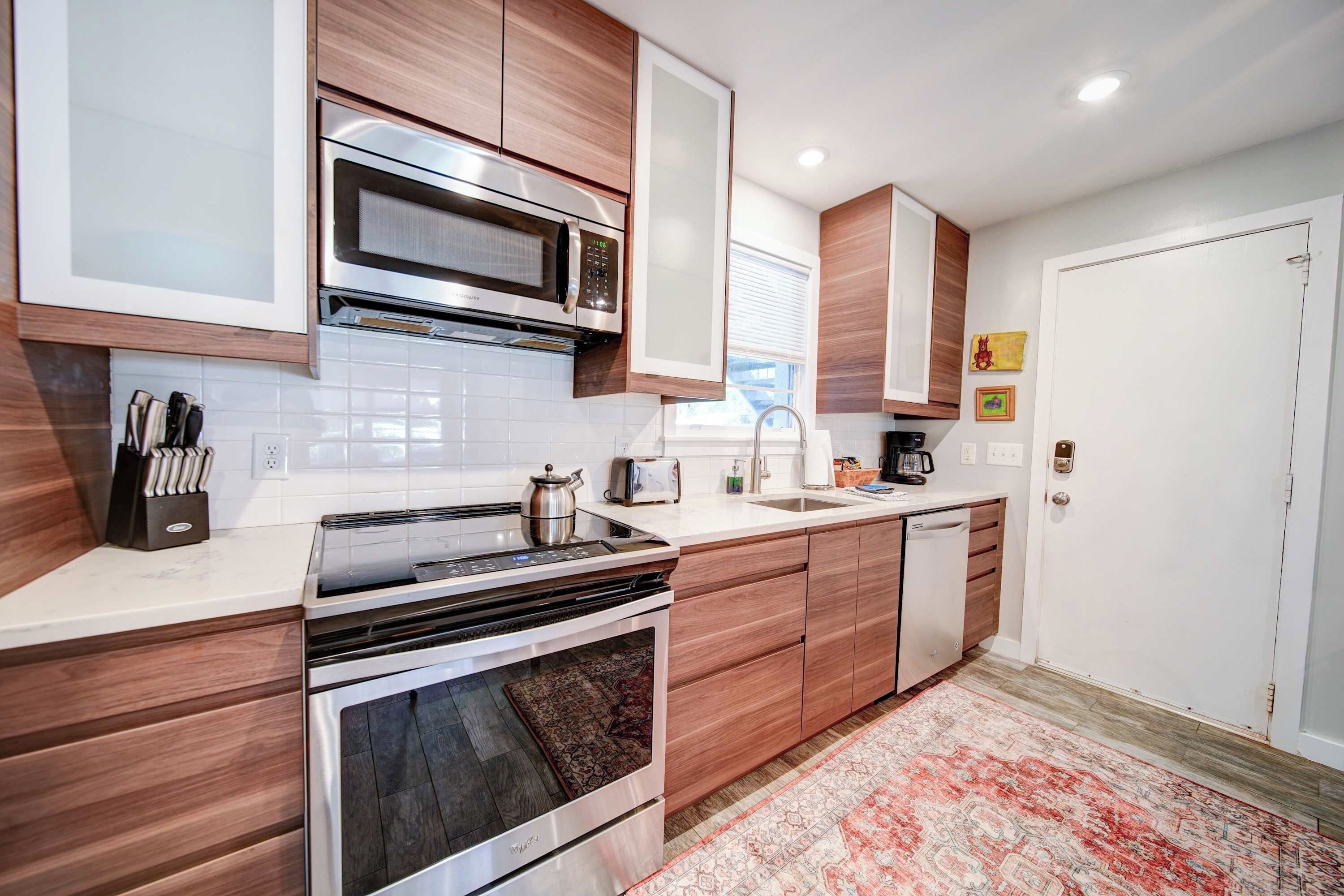 A modern kitchen with a built-in oven, microwave, and a coffee maker on the counter.