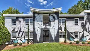 Un bâtiment moderne dont la façade est ornée d’une fresque murale originale en noir et blanc.