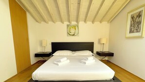 A modern hotel room with a large bed, two bedside tables, and a wooden ceiling. - Luxury View Terrace Apartment (Firenze)