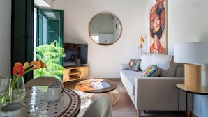 En moderne stue med sofa, sofabord og fjernsyn.