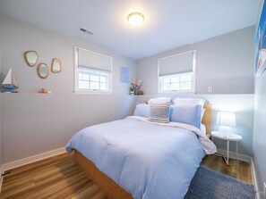 A bedroom with a bed, bedside tables, a lamp, and a window. - Playful, walkable, and comfortable, just steps from Mass Street. (Lawrence)
