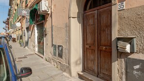 A narrow street with a wooden double door, a mailbox, and a building number 35. - 'Borghetto House - Pisa' Apartment with Private Terrace and Wi-Fi (Pisa)
