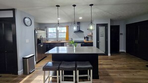 A modern kitchen with a central island, stainless steel appliances, and pendant lighting. - A+ location: UT, Melton Hill Parks, ORNL, shops (Oak Ridge)
