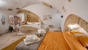 Moderni spa-huone, jossa on sänky, hierontapöytä ja seinälle asennettu taideteos.