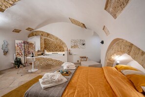 A modern spa room with a bed, a massage table, and a wall-mounted art piece. - GuestHost - Charming room of about 40 square meters, ideal for two people, located on the ground floor of a historic building (there is a small step at the entrance). Furnished with taste and attention to detail, it offers a warm and suggestive atmospher (Bari)