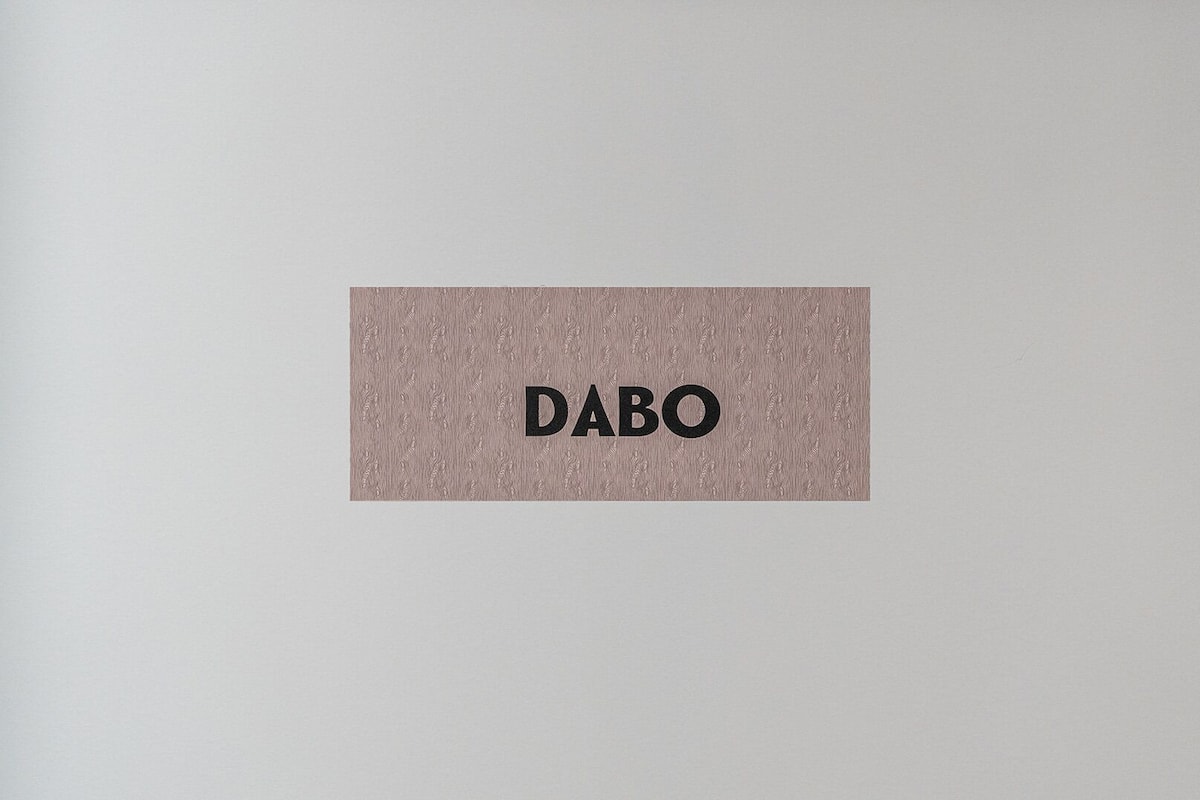 Una parete strutturata con la scritta "DABO" in caratteri marcati.