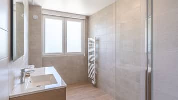 Ein modernes Badezimmer mit großem Fenster, integriertem Waschbecken und Handtuchhalter.