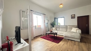 Apartamento Deluxe, 2 habitaciones, vistas parciales al mar | Zona de estar | Televisión de pantalla plana de 40 pulgadas con canales por cable