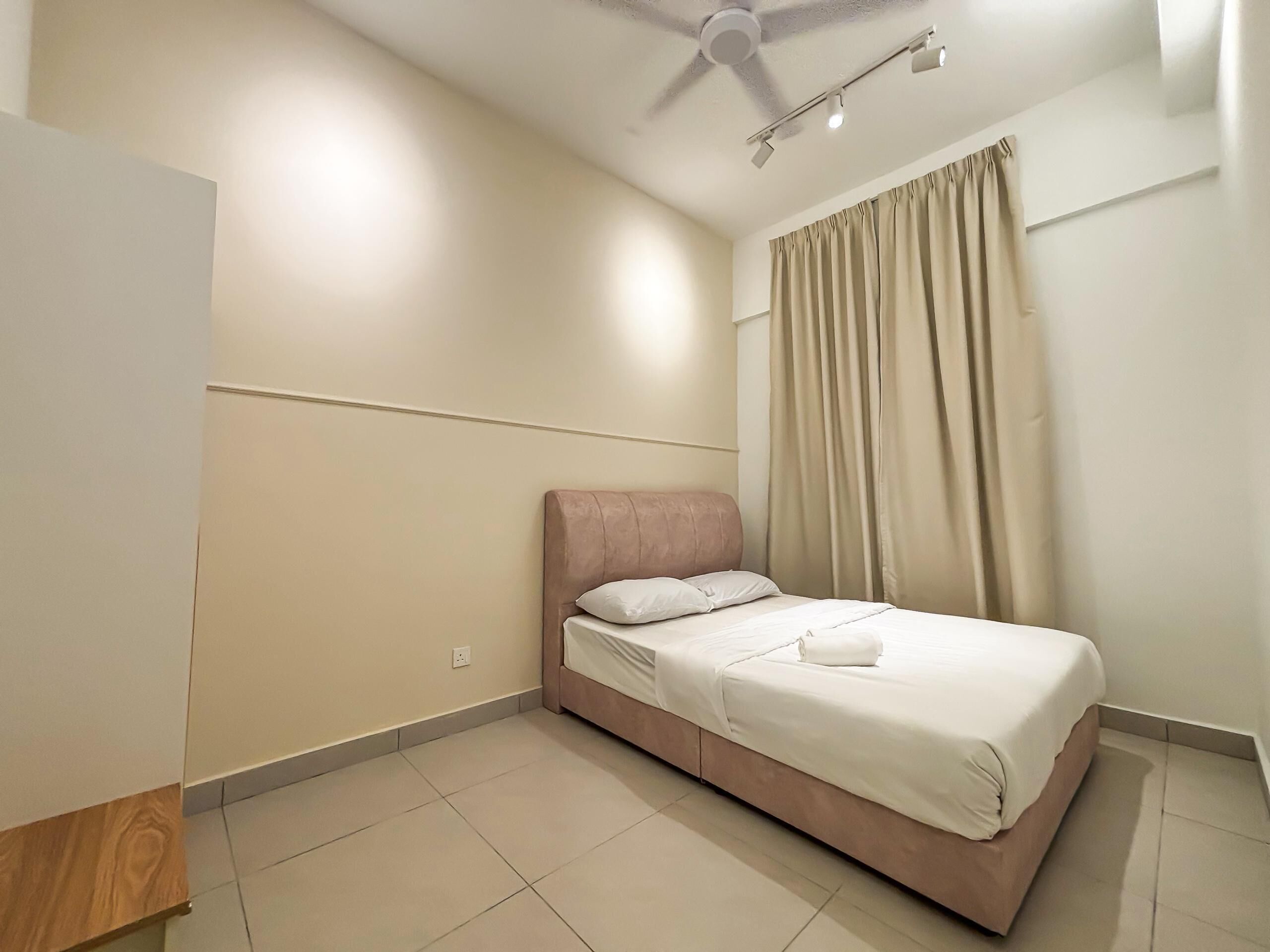 Ein Schlafzimmer mit einem Bett, einem Deckenventilator und einem Fenster mit Vorhängen.