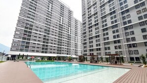 A modern residential building with a swimming pool, high-rise balconies, and a covered outdoor area. - Homestay 168 Park Mall  (Batu Caves)