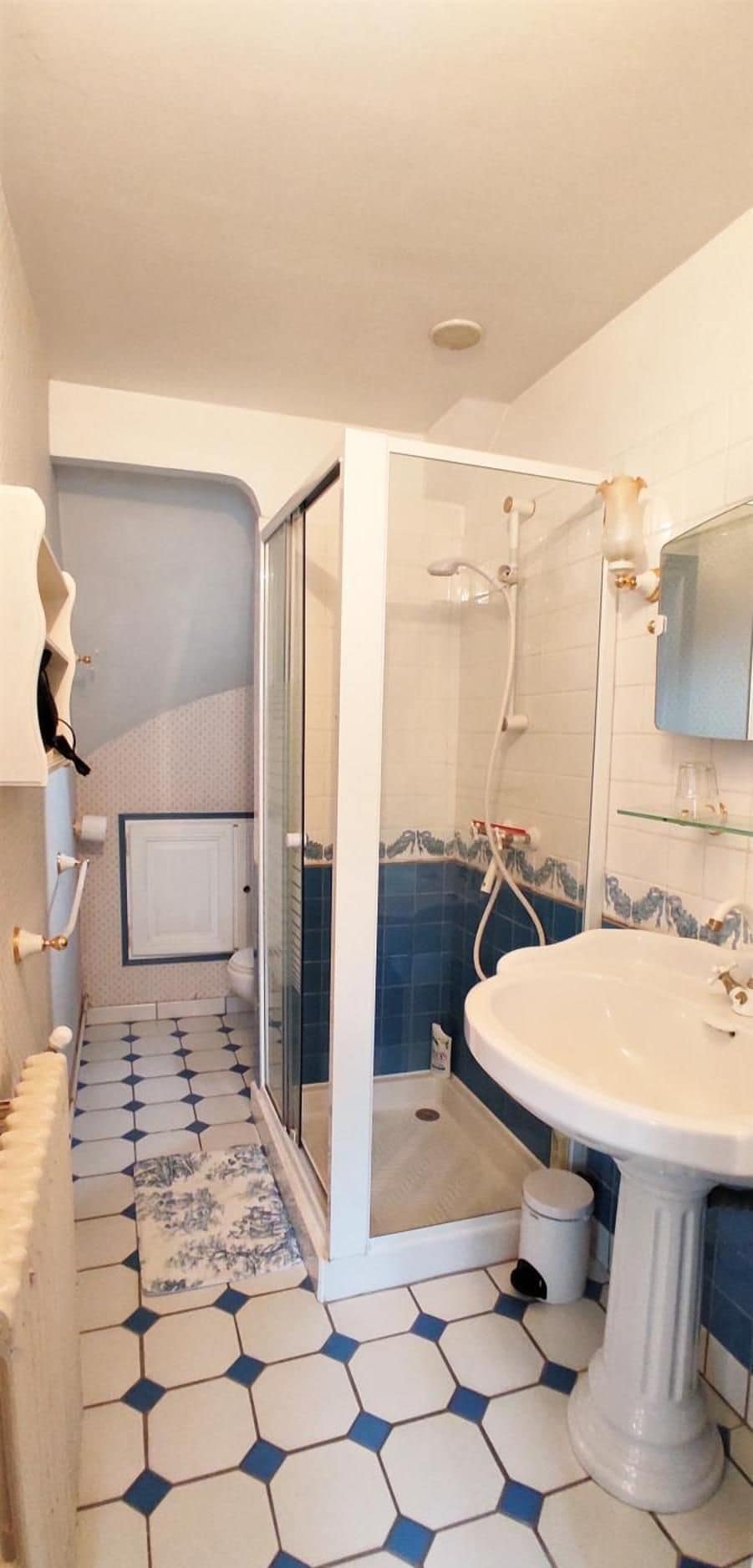 A bathroom with a shower, a sink, and a toilet.