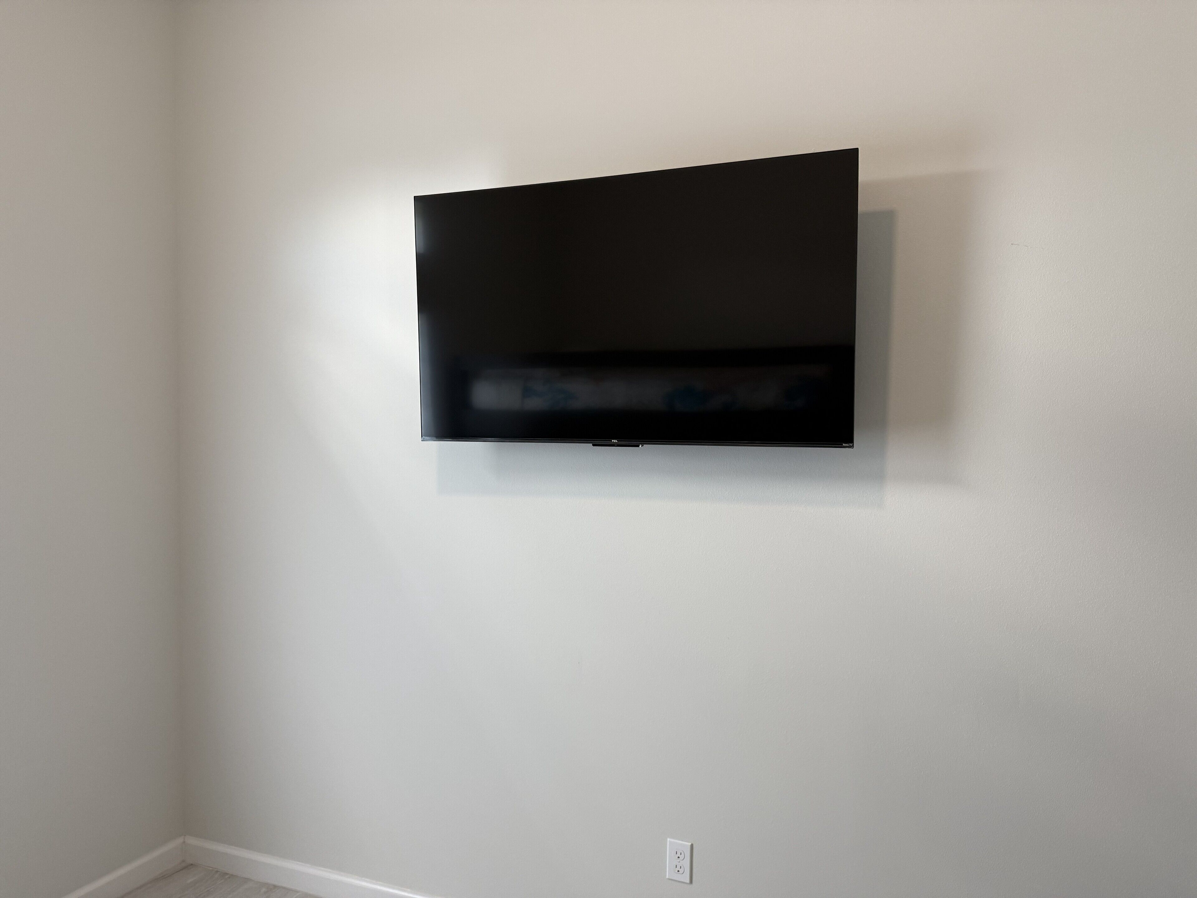 A flat-screen TV mounted on a plain white wall.