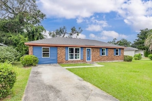 A single-story house with a brick facade and blue trim.