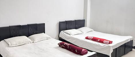 A hotel room with two single beds, a ceiling fan, and a wall-mounted coat rack.