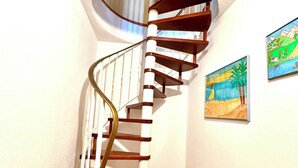 A spiral staircase with wooden steps and a metal railing, leading to an upper floor. - Cozy and quiet garden vacation apartment in the heart of Dießen am Ammersee (Dießen am Ammersee)