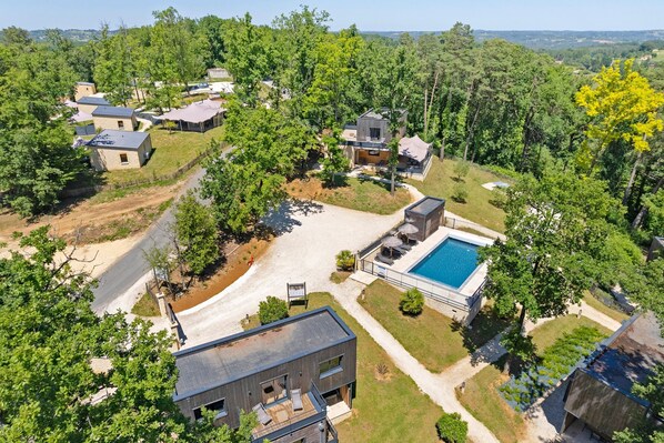 A residential area with modern houses, a swimming pool, and a well-maintained lawn.