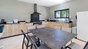 A modern kitchen with a central island, built-in appliances, and a large window.