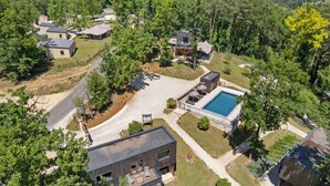 An aerial view of a residential area with multiple houses, a swimming pool, and a well-maintained lawn. - Le Pech Eternel - Lodge Spa Acacias (Sarlat la Canéda)