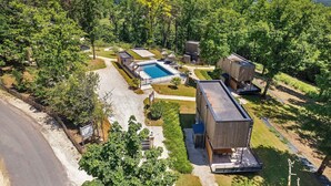 Ein modernes Resort mit Schwimmbad, Holzhütten und einem gepflegten Rasen.