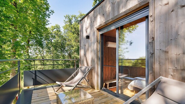 Eine Holzterrasse mit Liegestühlen und einem Korpusfußhocker.