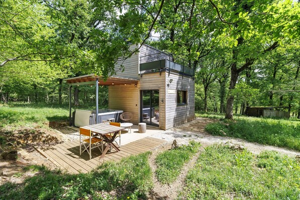 Une cabane moderne dotée d’une terrasse, d’un espace salon extérieur et d’un bain à remous.