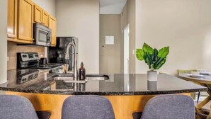 A modern kitchen with granite countertops, stainless steel appliances, and wooden cabinets. - Playhouse Square Condo /  Free Parking / Downtown (Cleveland)