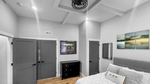A bedroom with a bed, a dresser, a wardrobe, and a ceiling light fixture. - Exquisite 1st Floor One Bedroom in Historic Marble Hill w/ Modern Amenities (Baltimore)