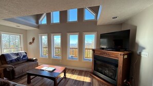 A living room with a fireplace, a television, and a sofa. - Spacious 4-bedroom + loft, 8 Min Drive to Resort, Equipped Hot Tub & Activities (Cass)