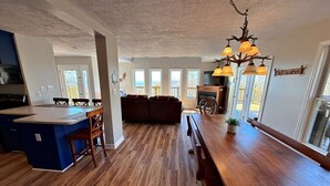 A spacious kitchen with a wooden island, a dining area with a long table, and a cozy seating area. - Spacious 4-bedroom + loft, 8 Min Drive to Resort, Equipped Hot Tub & Activities (Cass)