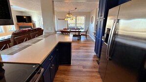 A modern kitchen with a central island, dark cabinetry, and stainless steel appliances. - Spacious 4-bedroom + loft, 8 Min Drive to Resort, Equipped Hot Tub & Activities (Cass)