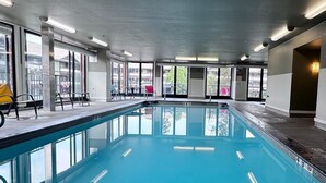 Una piscina interior con un letrero que dice 'NO DIVING', ventanas amplias y piso de baldosas.
