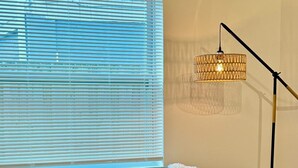 Un soggiorno moderno con un divano grigio, un cuscino decorativo, un tavolino con una candela e una lampada da terra.
