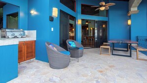 An outdoor patio area with wicker furniture, a barbecue grill, and a dining table. - Breathtaking views on the pacific ocean - inifnity edge pool (Dominicalito)