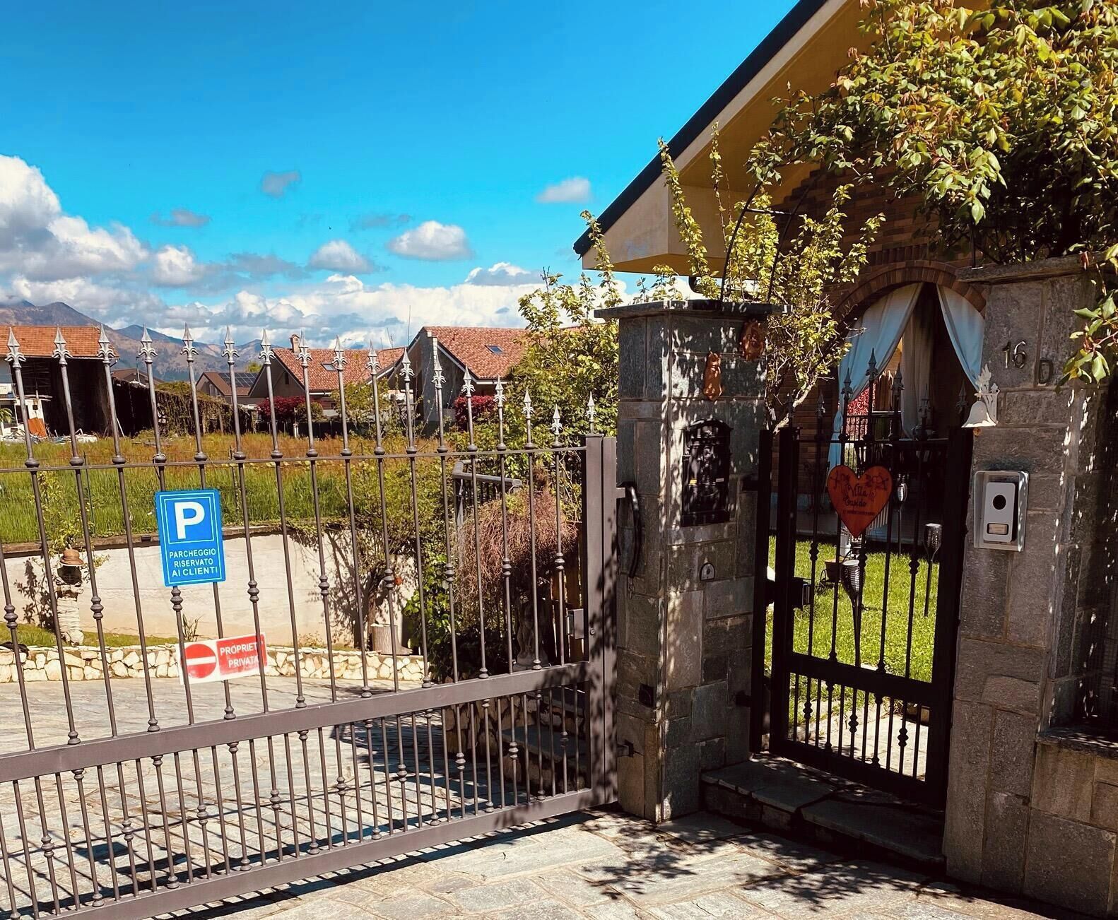 Uma entrada fechada com um edifício de pedra, uma placa de estacionamento e uma placa de propriedade privada.
