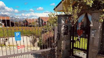 Uma entrada fechada com um edifício de pedra, uma placa de estacionamento e uma placa de propriedade privada.