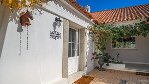 A building with a white exterior, a tiled roof, and a sign reading 'Orange Blossom.' - Room 'Orange Blossom Grove -  2' with Shared Terrace, Wi-Fi and Air Conditioning (São Bartolomeu de Messines)