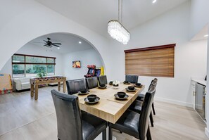 A dining area with a long wooden table set for six, surrounded by black leather chairs. - Phoenix, Pool, Hottub, basketball court, arcades, mountain views and much more! (Phoenix)