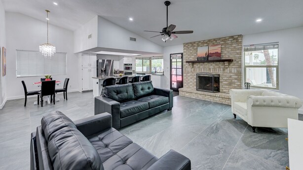 A spacious living area with a fireplace, a dining area, and a kitchen.