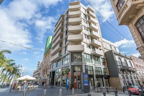 A multi-story hotel with balconies, a ground floor restaurant, and a visible sign for a hotel named 'Hotel Capital.'